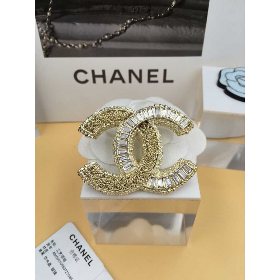 Золотая брошка Chanel камни